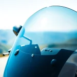 View a motorcycle windshields installed on a sleek motorcycle parked on a scenic road.